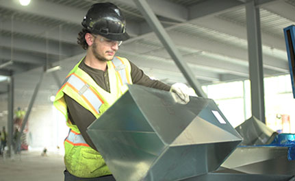 Sheet Metal Workers Union Member holding a piece of duct work